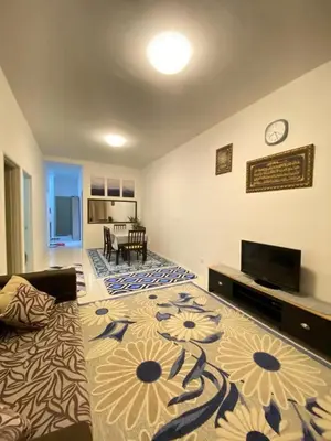 a living room with a couch and a tv at Aurora Inap Stay for Mslim Only in Cameron Highlands