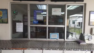 a store front window with signs on it at Railway Hostel in Batu Gajah