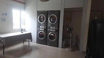 a room with four washing machines in a room at Railway Hostel in Batu Gajah