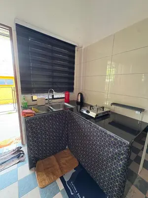 a kitchen with a sink and a counter top at Nadis Guesthouse in Ipoh