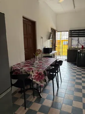 a dining room table with a floral table cloth on it at Nadis Guesthouse in Ipoh
