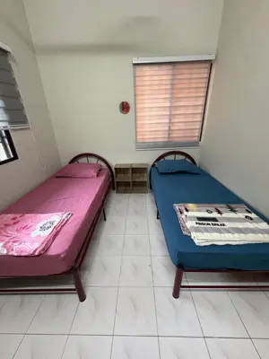 two beds sitting in a room with a window at Nadis Guesthouse in Ipoh