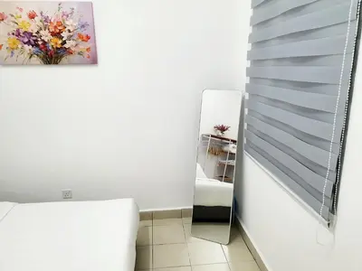 a room with a mirror next to a white chair at Awan Homestay Cameron Highlands in Tanah Rata