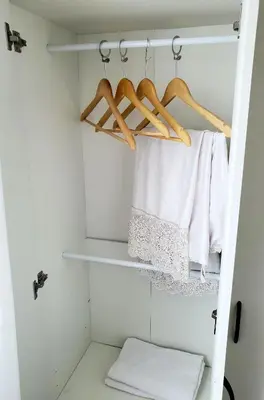 a closet with white towels and wooden hangers at Awan Homestay Cameron Highlands in Tanah Rata