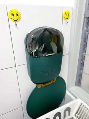 a green toilet in a bathroom with smileys on the wall at Awan Homestay Cameron Highlands in Tanah Rata