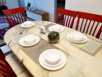 a wooden table with white plates on it at Awan Homestay Cameron Highlands in Tanah Rata