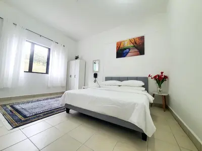 a white bedroom with a large bed and a window at Awan Homestay Cameron Highlands in Tanah Rata