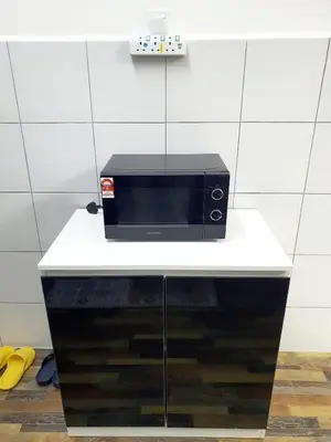 a black microwave sitting on top of a counter at Awan Homestay Cameron Highlands in Tanah Rata