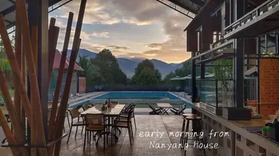 a patio with a table and chairs next to a swimming pool at The Lumpang Resort in Kerling