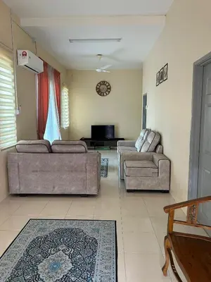 a living room with two couches and a tv at Homestay Stop in Gua Sai