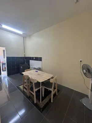 a room with a table with chairs and a fan at Homestay Stop in Gua Sai