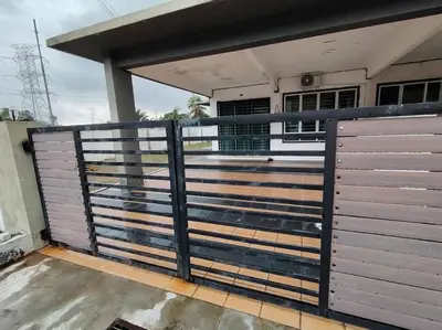 a metal fence with a gate in front of a house at Homestay Stop in Gua Sai