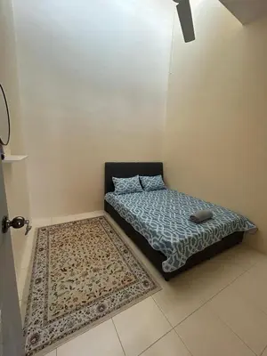 a small bed in a room with a rug at Homestay Stop in Gua Sai