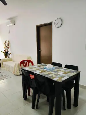 a dining room table with chairs and a clock on the wall at Ryhan-Cha Homestay near Afamosa Waterpark in Gua Sai