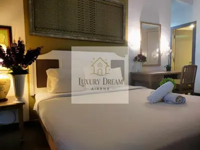 a hotel room with a bed with a luxury drew logo at Luxury Dream Seaview in Tanjung Bungah