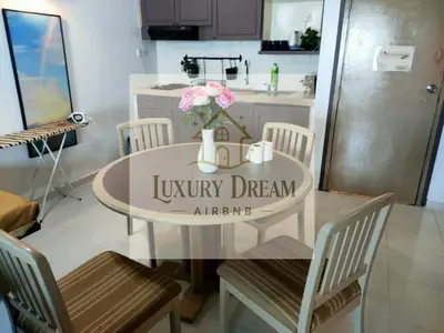 a kitchen with a round table with flowers on it at Luxury Dream Seaview in Tanjung Bungah