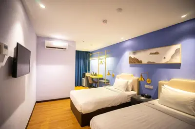 a hotel room with two beds and a desk at Embassy Hotel Georgetown in George Town