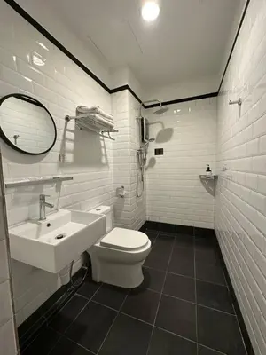 a bathroom with a toilet and a sink at Embassy Hotel Georgetown in George Town