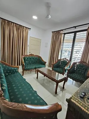 a living room with green couches and a coffee table at Bertam Perdana Homestay