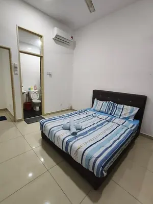 a bedroom with a bed and a bathroom with a mirror at Bertam Perdana Homestay