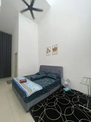 a bed in a room with a ceiling fan at The Indah Homestay Gerik in Gerik