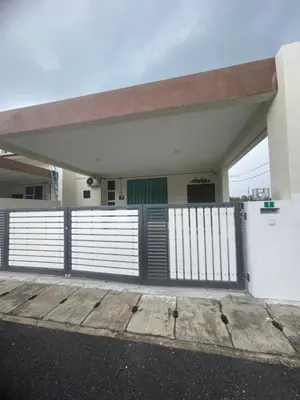 a white building with a gate and a fence at The Indah Homestay Gerik in Gerik
