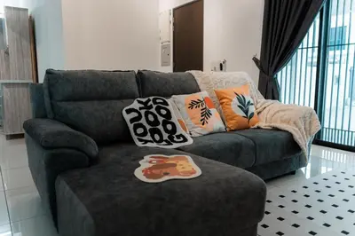 a couch with pillows on it in a living room at SpaciousFun4BR Home 9Pax 3Bath Snooker ALMA in Bukit Mertajam