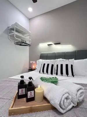 a bedroom with a bed with two candles on it at NEW Georgetown 22 Macalisterz Elegant 2BR 5pax in George Town