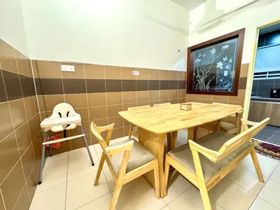 a dining room with a wooden table and chairs at Klebang Cozy Homestay in Chemor