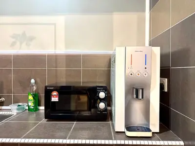 a microwave oven sitting next to a coffee maker at Klebang Cozy Homestay in Chemor