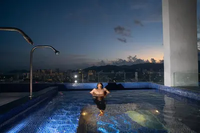 a woman in a swimming pool on top of a building at 22 Macalisterz George Town By Mana-Mana in George Town
