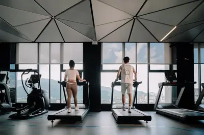 two people exercising on tread machines in a gym at 22 Macalisterz George Town By Mana-Mana in George Town