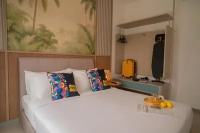 a bedroom with a large white bed and a yellow suitcase at 22 Macalisterz Leisure Suites George Town in George Town
