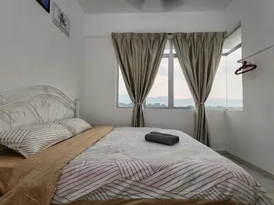 a bedroom with a large bed with a large window at Aplan Falim by Irainbow in Ipoh