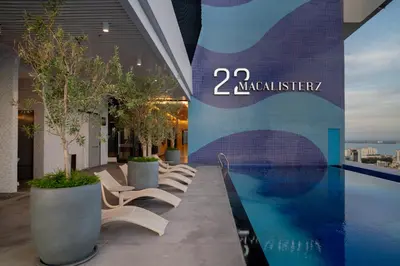 a group of chairs sitting next to a swimming pool at 22 Macalisterz George Town By KLIQ in George Town