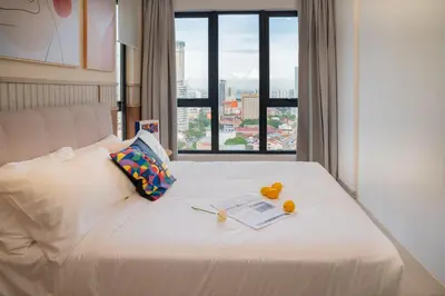 a white bed with fruit on it with a window at 22 Macalisterz George Town By KLIQ in George Town
