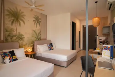 a hotel room with two beds and a desk at 22 Macalisterz George Town By KLIQ in George Town
