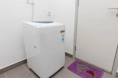 a small bathroom with a toilet and a purple rug at Jazz Service Suite Penang in Tanjong Tokong