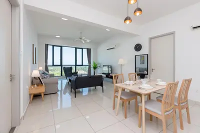 a dining room and living room with a table and chairs at Jazz Service Suite Penang in Tanjong Tokong