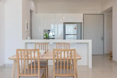 a kitchen with a wooden table and four chairs at Jazz Service Suite Penang in Tanjong Tokong
