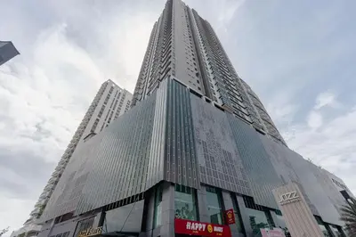 a tall building with glass windows in a city at Jazz Service Suite Penang in Tanjong Tokong