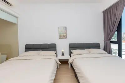 two beds in a room with a window at Jazz Service Suite Penang in Tanjong Tokong