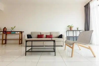 a living room with a couch and a table and a chair at Beacon Executive Service Suite Penang in George Town