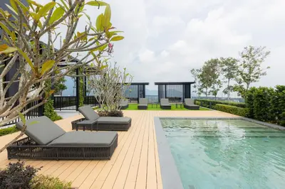 a swimming pool with chaise lounge chairs next to a house at Beacon Executive Service Suite Penang in George Town