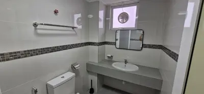 a white bathroom with a sink and a mirror at A357 Silverpark Resort Best Mountain view in Bukit Fraser