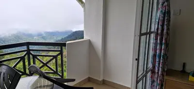 a room with a balcony with a view of the mountains at A357 Silverpark Resort Best Mountain view in Bukit Fraser