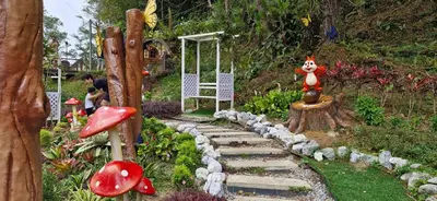 a garden with a pathway with a toy squirrel on a tree at A357 Silverpark Resort Best Mountain view in Bukit Fraser