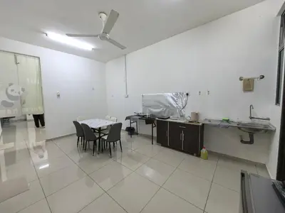 a room with a table and chairs and a kitchen at Padang Serai Wangi Homestay 402 in Padang Serai
