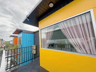 a yellow building with a balcony with a window at 69 Comfortainer Homestay in Taiping