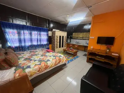 a bedroom with a bed and a tv in it at Capital O 91206 Homestay Pelangi Ban Pecah. (muslim Only)
